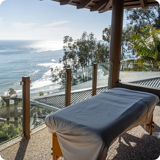 An ocean-view massage table on a sunny terrace